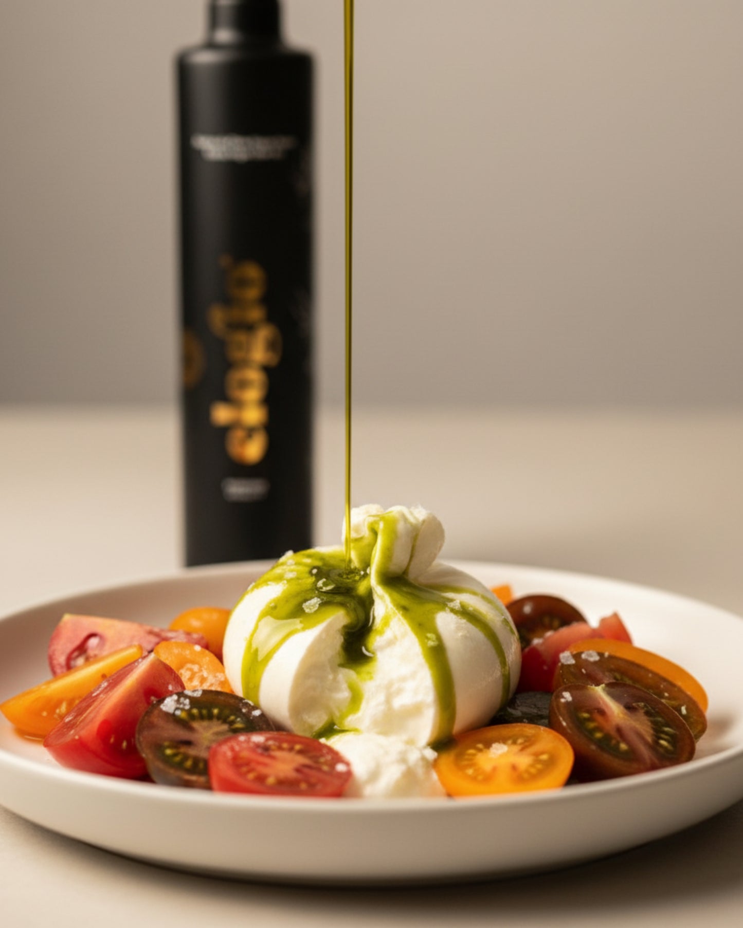 Aceite de oliva Elogio Premium aliñando una ensalada de tomate y burrata